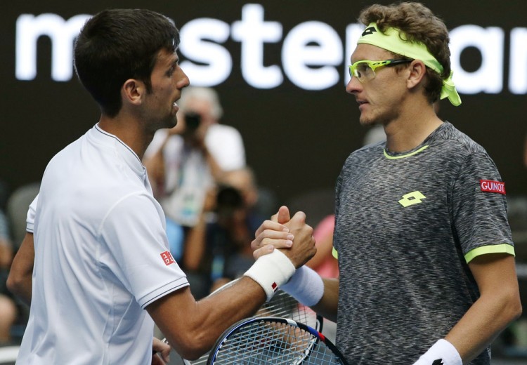 Novak Djokovic e Denis Istomin  se cumprimentam após o jogo (Mark Baker/Associated Press)